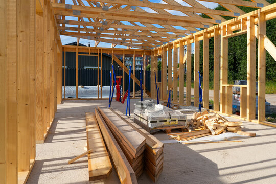 Timber Frame House Interior Under Construction with Lumber, Roof Trusses and Utility Installation Work