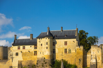 Majestic medieval French castle with stone towers on a beautiful autumn day in France. Ancient chateau fortress under a blue sky with clouds. © Bill Lezos