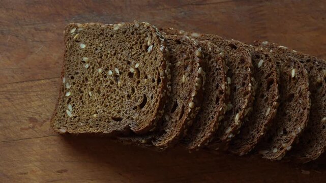 Closeup of freshly baked wholegrain gluten free bread slices with visible seeds and rustic texture perfect for healthy eating. Rotation of rye bread slices, detailed 4k 