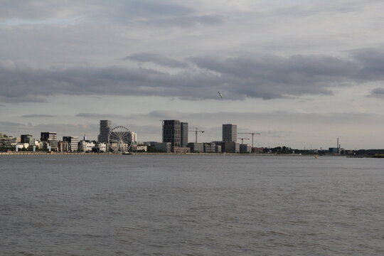 a skyline of belgian city antwerp with big residential towers at the left quay with a beautiful view at the westerschelde river