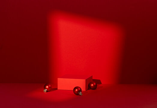 Red Christmas Scene with Ornament Balls, Blank Card and Diagonal Light Beam on Dark Red Background