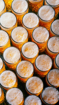 Overhead pattern of frothy beer mugs filled with golden lager at festive Oktoberfest celebration