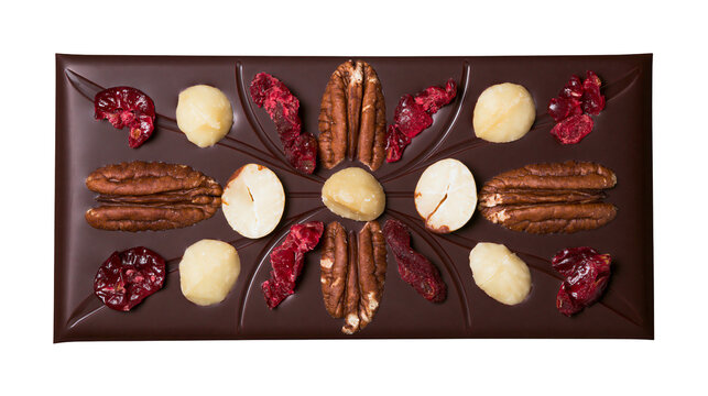 Dark chocolate bar with pecans macadamia nuts and dried cranberries, isolated on transparent background