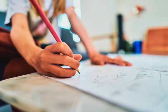Child drawing with a pencil - close-up of hand sketching on paper