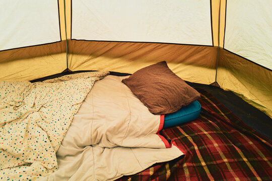 Inside a camping tent - sleeping bag and bedding laid out
