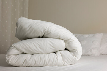 Obraz premium Soft White Duvet Folded on Bed in Cozy Bedroom Interior 