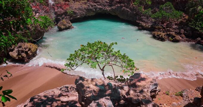 Wild secluded beach, hidden tropical beach lagoon with turquoise water and natural rock cave in Dominican republic