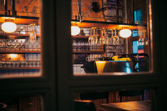 Glasses hanging on a rail in a bar or a restaurant.