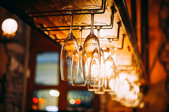 Glasses hanging on a rail in a bar or a restaurant.
