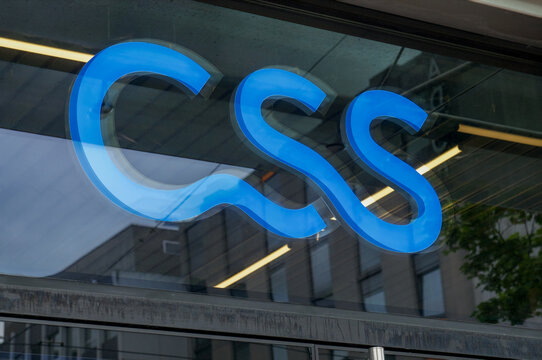 Close up of the blue CSS insurance company sign behind a glass window in Switzerland