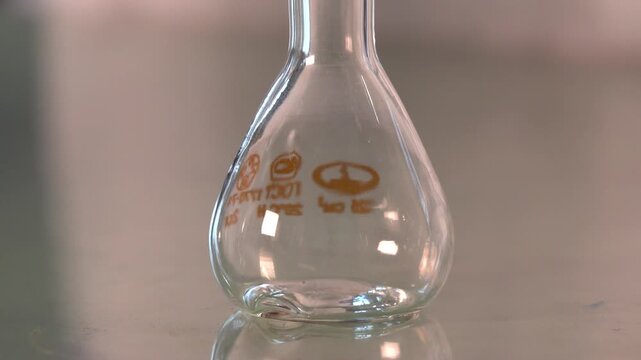 Close-up footage of a laboratory experiment with test tubes and glassware, featuring bubbling and mixing liquids. Scientific research process in a modern lab environment, showcasing chemical reactions