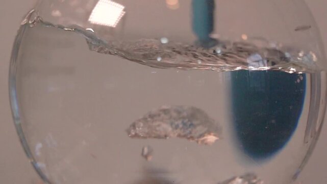 Close-up footage of a laboratory experiment with test tubes and glassware, featuring bubbling and mixing liquids. Scientific research process in a modern lab environment, showcasing chemical reactions