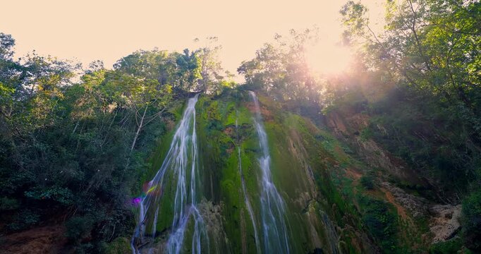 Waterfall in tropical jungle forest with bright sunlight rays Dominican republic El Limon cascade