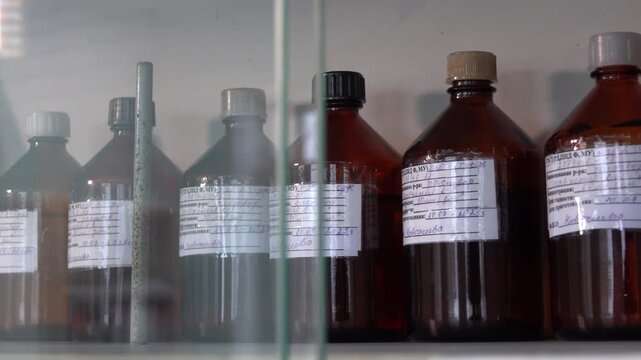 Close-up footage of a laboratory experiment with test tubes and glassware, featuring bubbling and mixing liquids. Scientific research process in a modern lab environment, showcasing chemical reactions
