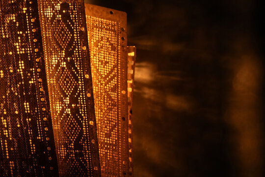 Antique Jacquard Loom Punch Cards Backlit with Warm Amber Light Showing Diamond Pattern Programming, Heritage Textile Technology Concept

