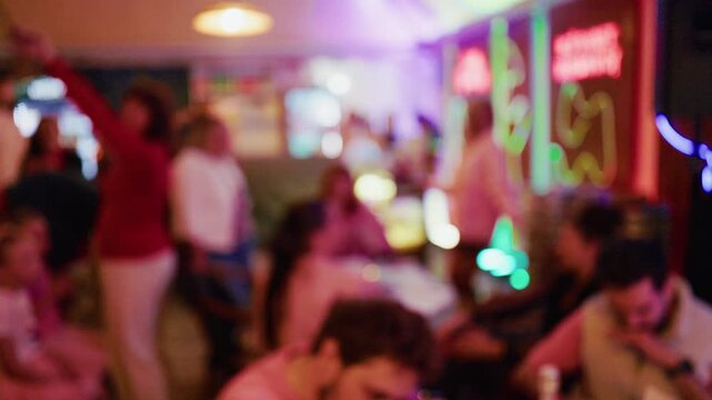 Blurred nightlife crowd inside neon lit bar with colorful lights and lively social atmosphere