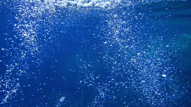 Sunbeams and bubbles underwater. Underwater slow motion bubbles moving to surface in turquoise crystal clear sea. air bubbles underwater bubbles coming up to the surface blue water ocean scenery. Pool