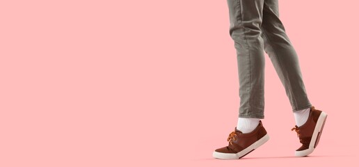 Fototapeta na wymiar Person walking in brown sneakers on pink background