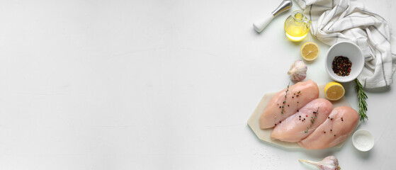 Fototapeta premium Raw chicken breasts with spices and lemon on white background