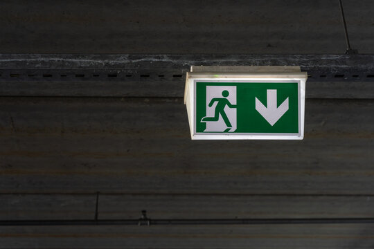 Emergency exit sign in parking garage as safety evacuation route and building compliance concept