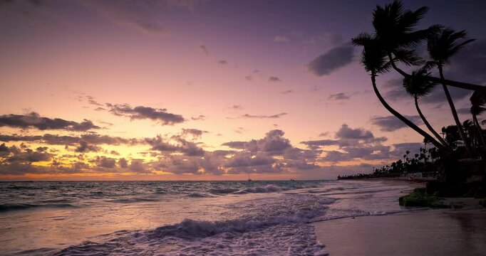 Sunset over Caribbean Sea and tropical beach with palm trees Punta Cana resort Dominican Republic