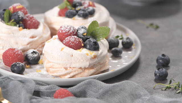Mini Pavlova Meringues Topped with Fresh Raspberries and Blueberries