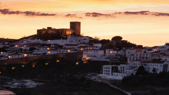 Scenic sunset view over the historic hilltop castle and white houses of Mertola in the Alentejo region of Portugal