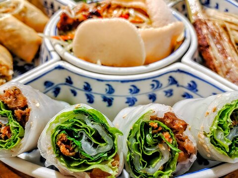 Close-up of a platter of assorted Authentic Vietnamese Rice Paper spring Rolls with crispy pork, lettuce and herbs