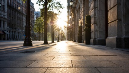 Obraz premium Sunlight bursting over empty city sidewalk at golden hour.