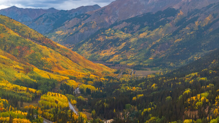 Obraz premium Aerial view of Colorado fall landscapes along Million Dollar Highway with views of mountainside fall foliage trees in San Juan Mountains during autumn season