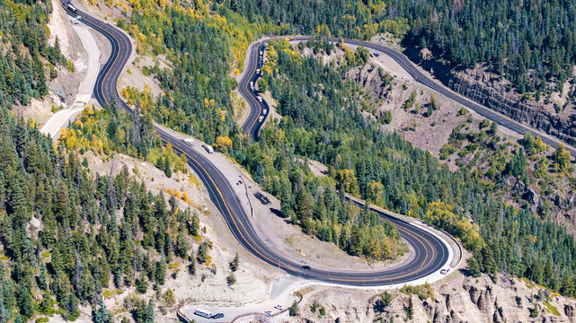 Aerial view of traffic on Highway 160 and Wolf Creek Pass in Pagosa Springs, Colorado fall landscapes capturing winding roads and colorful trees during autumn season