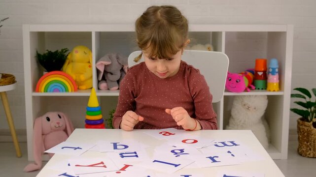 The child learns English letters. Selective focus.