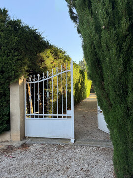An open metal gate leading to a house, Provence, France