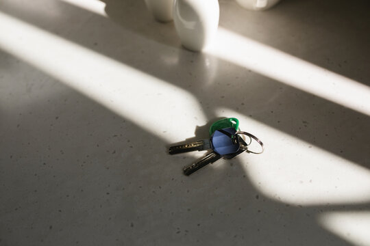 Close-up of two keys on a keyring on a kitchen table in sunlight