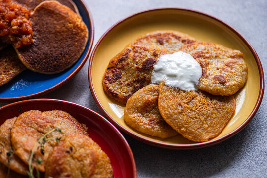 Close-up of three different coloured plates with Potato pancakes (draniki) and various sauces