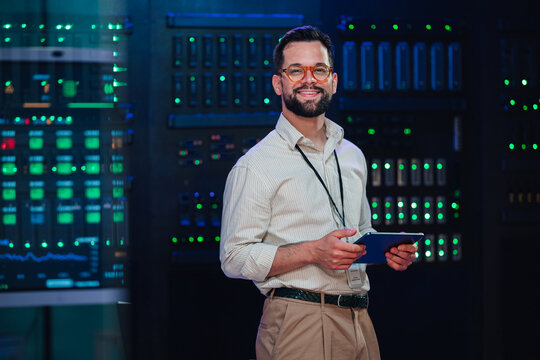 It expert smiling in data center managing cloud computing infrastructure and digital network operations