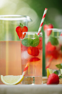 Close-up of a glass filled with carbonated strawberry lemonade and mint.