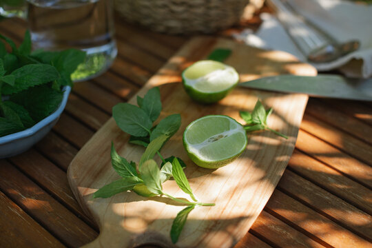 Close-up of Fresh limes and mint leaves on a sunny garden table in summer