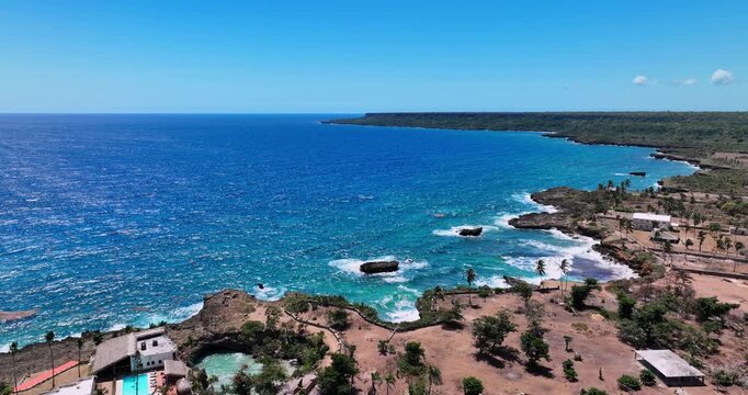 Ocean Waves Crashing Against Rocky Cliffs Along a Coastal Beach, Caribbean sea shoreline, Boca De Yuma, Dominican Republic aerial landscape
