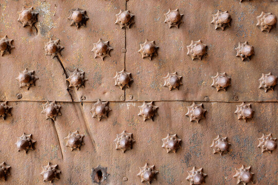 Close up detail of beautiful ornate metal door with metal studs, Genoa