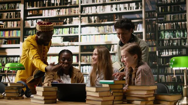 Smiling diverse students stacking hands together in unity at library table, celebrating teamwork and successful group study session, classmates united in academic work, for student learning.