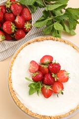 Obraz premium Yummy cheesecake with strawberries and mint on beige table, flat lay