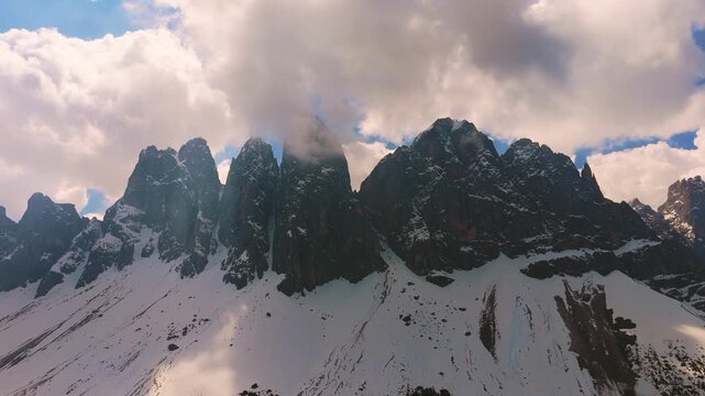 Dynamic aerial hyperlapse of clouds moving over the Odle mountain range in Puez-Geisler, Dolomites