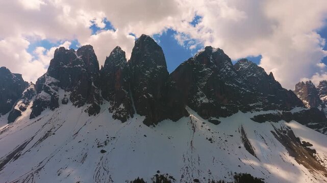 Sharp limestone pinnacles of the Odle Puez Geisler mountain range in low alpine clouds. Dolomites aerial