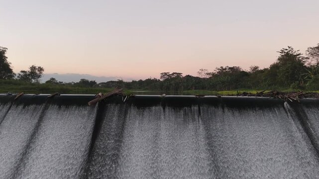 Lush Riverscape Reveal over a Java Dam at Sunset.