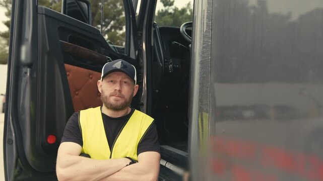 Professional truck driver posing next to his semi-truck