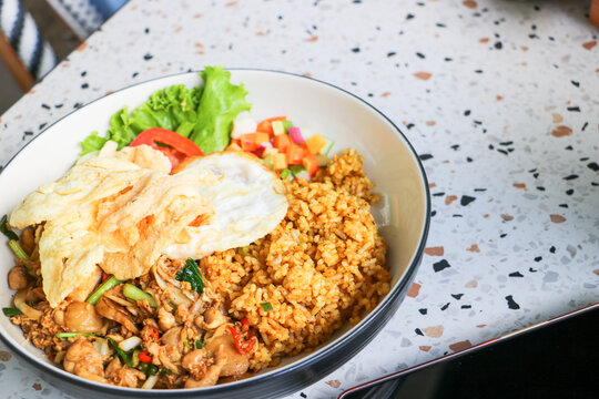 Traditional recipe of Indonesian fried rice paired with fried egg and savory emping crackers