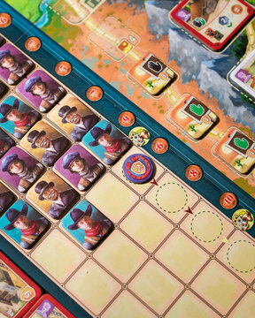 Portrait close up product photography of Great Western Trail components showing building tokens worker tokens and train pieces designed by Alexander Pfister and Chris Quilliams