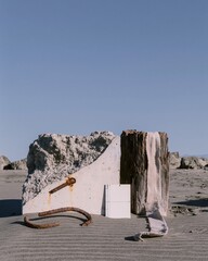 Fototapeta premium Fractured concrete seawall and weathered timber piling with rusted rebar on a sandy beach for coastal erosion and climate change research