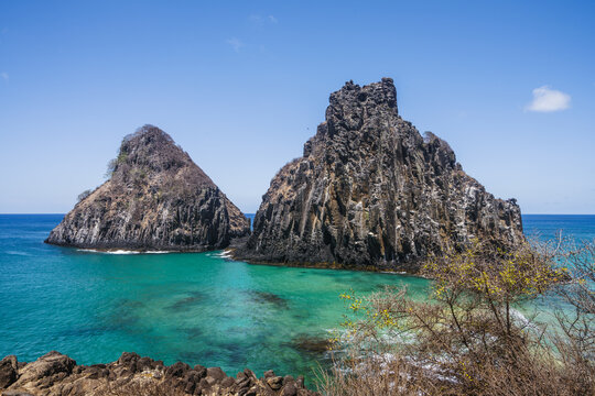 The twin Dois Irmaos rocks and turquoise sea, Fernando de Noronha, Pernambuco, Brazil